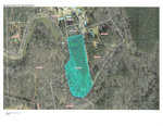 Aerial view of a parcel of land highlighted in turquoise within a wooded area, showing property boundaries and parcel numbers, as depicted on the vance county tax parcel viewer.