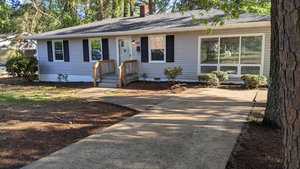 A house with a driveway and trees.