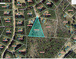 Aerial view of a rural area with parcels of land, each marked with annotations, highlighting a triangular-shaped property in the center.