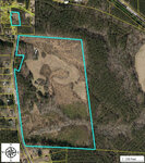 Aerial view of a parcel of land at 1716 Gun Club Road, Henderson NC, outlined in blue, featuring a mix of wooded areas and open fields, with adjacent roads and properties.