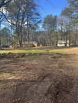 A clear day over a residential area at 0 Bullock Street, Henderson NC, with a view of bare trees, a well-kept lawn, and houses in the distance.