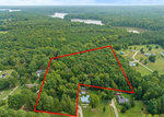 Aerial view of a forested property with outlined boundaries, adjacent to a rural residential area at 0 Hicks Street, Henderson NC.