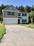 Two-story residential home at 90 W Boulder Drive, Henderson NC, with an attached two-car garage and a property management sign in the front yard.