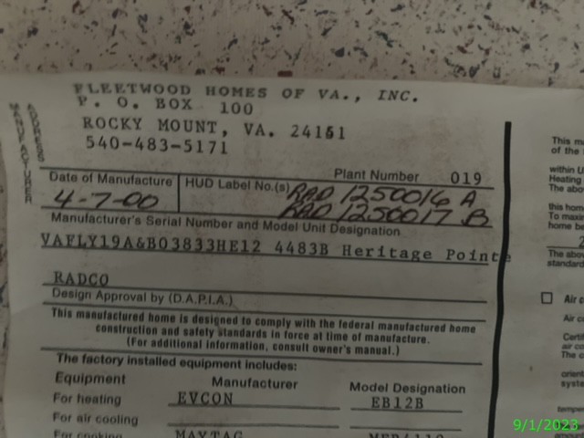Manufactured home label detailing the serial number, model, and compliance information with a date stamp visible in the corner.