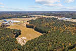 Aerial view of a rural landscape along 0 Garrett Road, Henderson, NC showing a patchwork of forested areas, open fields, and several buildings.