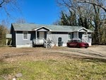 A house at 985/987 Hughes Street, Henderson NC, with a red car parked in front of it.