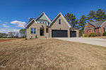 New suburban house at 408 Eagle Court, Henderson NC, with a two-car garage and a freshly sodded front lawn under a clear blue sky.