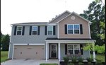 Two-story house at 29 W Waycliff Road, Henderson NC, with beige siding and dark brown shutters, featuring a double garage and a small covered entryway, surrounded by grass and trees