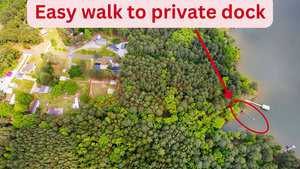Aerial view reveals a wooded area with a path leading to a private dock on the lake near 198 S Piney Grove Road in Manson. Red text states "Easy walk to private dock," with arrows and circles highlighting the path and dock. Nearby houses and roads are clearly visible.