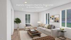 A digitally staged and renovated living room with modern furniture. It features a beige couch, armchair, coffee table with books, potted plant, and wall art. Large windows and recessed lighting brighten the space, highlighting the wooden floor.