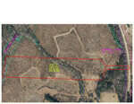 Aerial view of a rectangular piece of land outlined in red, labeled "Tract A: 10.96 acres" near 7711 Cornwall Road, Oxford. The surrounding area includes sparse vegetation and a road on the right. A turquoise-marked creek meanders along the left side of the image.