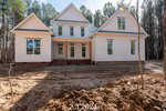 A newly constructed white house with a pitched roof stands in a clearing at 3608 Horseshoe Road, Creedmoor, surrounded by tall trees. The ground in front is unlandscaped dirt. The date "2.3.2024" is overlaid at the bottom.