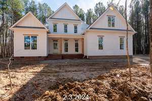 A newly constructed white house with a pitched roof stands in a clearing at 3608 Horseshoe Road, Creedmoor, surrounded by tall trees. The ground in front is unlandscaped dirt. The date "2.3.2024" is overlaid at the bottom.