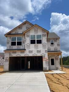 Located at 200 Shelfit Trail, this newly constructed two-story house in Oxford boasts wrap-around construction material and expansive windows. A partly cloudy sky hovers over the site, where ongoing development hints at the promise of a flourishing neighborhood.