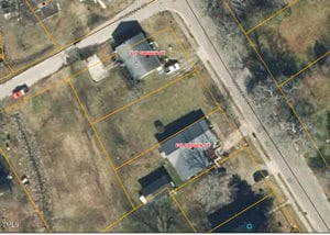 Aerial view of two adjacent properties outlined in yellow. One is labeled "817 Goshen St" and the other "819 Goshen St." Both have houses and small yards with trees. Roads border the properties on two sides.