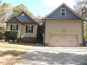 Located at 2704 Langstroth Court in Franklinton, this single-story house boasts a double garage in a tranquil suburban setting. The exterior features elegant beige siding with dark blue accents, while a charming staircase guides you to the front door. Surrounded by trees, it offers a neatly maintained yard and gravel driveway.