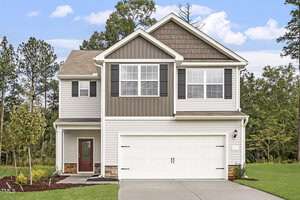 A two-story suburban house at 207 Shelfit Trail, with a mix of gray and white siding, is pictured. It features a double garage and a small porch. The driveway and front yard are neatly maintained, framed by trees under an Oxford-blue, partly cloudy sky.