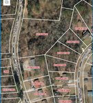 Aerial view of a residential area in Henderson, showcasing houses and streets. Property lines are marked in white with red identification numbers. Roads like 2.07 Old Epsom Road, Old Creedmoor Rd, and Ridgecrest Trl are visible, all surrounded by lush trees.