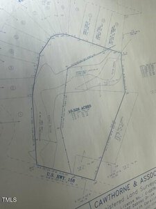 A blueprint featuring a land plot, labeled as 10.526 acres, outlined with measurements. The plot is adjacent to U.S. Highway 158. Surveyor details are in the bottom-right corner. Various contour lines and annotations are visible.