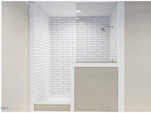 A modern shower with white subway tiles and a glass partition. The showerhead is mounted on the right wall. A light-colored tiled step leads into the shower area. The ceiling features recessed lighting.