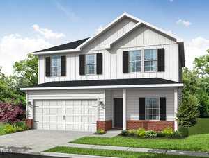 A two-story house at 112 Hays Street, Oxford, features white siding, black shutters, a black roof, and a double garage door. Enjoy the small front porch, brick trim at the base, manicured lawn with bushes, and a clear sky with some clouds.
