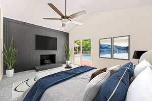 A modern bedroom with a large bed, blue and white bedding, two wall paintings, a black accent wall with a TV and fireplace, plants, and sliding glass doors opening to a pool area.