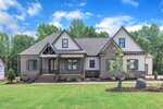 A newly built, single-story suburban house at 3920 Cedar Knolls Drive, Youngsville features dark brick and white siding exterior, gable roofs, front steps, young landscaping, and a large grassy lawn on a clear, sunny day.