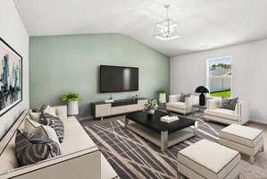 A modern living room with light-colored furniture, a black coffee table, a large wall-mounted TV, and a window showing a green yard. The walls are painted white and green, and a geometric rug covers the floor.