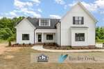A modern white two-story house with black trim, multiple windows, and a gable roof sits on Lot 19 Spring Grove Drive in Oxford, set on a bare dirt lot with minimal landscaping. ECI Construction and Hatcher Creek logos are overlaid at the bottom.