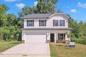 A two-story suburban house with white siding, black roof shingles, a double garage, and a front lawn. Located at 110 Hays Street in Oxford, it features a real estate sign near the driveway with trees and blue sky in the background.