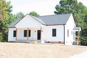 A single-story white house with black trim at 341 Rev Henderson Road, Henderson, features a gabled roof, wooden porch columns, and a small entry porch. The yard is mostly bare soil with green trees in the background.