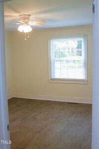 Empty room at 2001 Thomas Lane in Henderson with light-colored walls, a ceiling fan with lights, wood-style flooring, and a window with blinds letting in natural light. The space is clean and unfurnished.