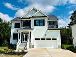 A two-story white house with black shutters and a double garage at 2651 Bowden Drive in Creedmoor, with front steps leading to a glass door entrance, a concrete driveway, and grassy surroundings under a partly cloudy sky.