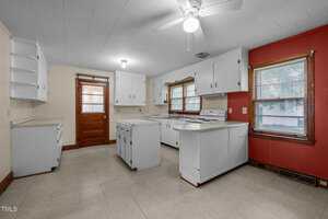 A kitchen with white cabinets and a ceiling fan.