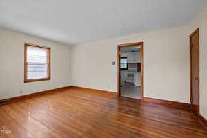 A room with a wood floor and a door.