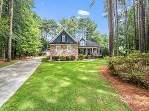 A two-story stone and siding house at 3651 Jordan Circle in Franklinton features a front porch, surrounded by tall trees and a large lawn. A curved concrete driveway leads to the home, bordered by shrubs and landscaped beds.