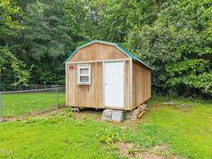 A small wooden shed in a yard.