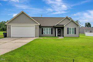 Single-story house at 316 Keeneland Drive, Oxford, featuring gray siding, a gable roof, an attached two-car garage, and a concrete driveway. The well-maintained front lawn complements the mostly clear sky with a few clouds.