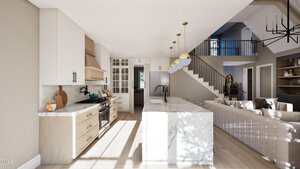 Modern kitchen with light wood cabinets, white upper cabinets, marble island with bar stools, and pendant lights. An open living area and staircase are visible in the background. Natural light fills the space.