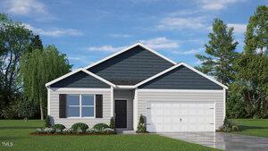 Single-story suburban house at 118 Ross Drive with dark blue siding on the gable, light-colored horizontal stem siding below, a black front door, double garage, landscaped yard with shrubs and grass, set against a backdrop of trees.
