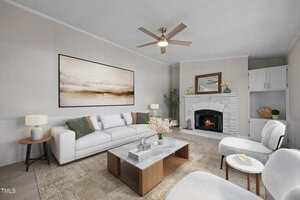 A modern living room with a white sofa, two white chairs, a marble coffee table, and a fireplace with a mirror above it. Neutral colors, abstract wall art, plants, and two side tables with lamps are present.
