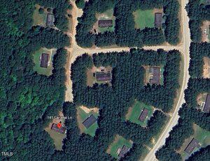 A satellite view shows several buildings surrounded by dense trees, intersecting roads, and an address pin marking "141 Cardinal Ln" on one building in the lower left quadrant.