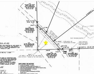 Black and white survey map showing property lines, road right-of-way, measurements, and notes. A large yellow star is marked near the center of the image, highlighting a spot along a curved property boundary.