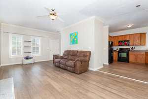 A living room with a couch and a kitchen.