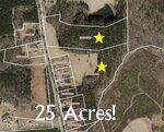 Aerial map view showing outlined property parcels in Henderson, wooded and open areas, two yellow stars marking locations, and "25 Acres!" across the center. Roads, adjacent lots, and 1140 Spring Valley Lake Road are also visible.