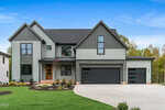 A modern two-story house at 3906 Cedar Knolls Drive, Youngsville, with gray siding, dark trim, large windows, and three garage doors. The front yard has green grass, young trees, and a wide driveway under a clear blue sky.