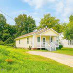 Charming home at 533 E Winder Street features a welcoming path and beautiful trees, creating a peaceful setting in Henderson, NC.
