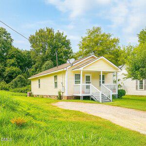 Charming home at 533 E Winder Street features a welcoming path and beautiful trees, creating a peaceful setting in Henderson, NC.