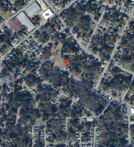A satellite view of a residential neighborhood with tree-lined streets and houses. A red location pin marks 533 E Winder St near the center of the image. Some larger buildings and parking lots are visible at the top.