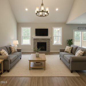 A living room with two gray sofas, a wooden coffee table, a fireplace with a TV mounted above it, a rug, and large windows letting in natural light. The room has neutral colors and a chandelier on the ceiling.
